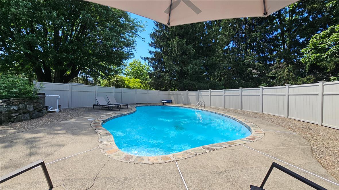 585 Buttermilk Road Hellertown, PA 18055 - Photo 43 of 82 An inviting backyard oasis, fully fenced and offering a private in-ground pool with ample concrete decking.