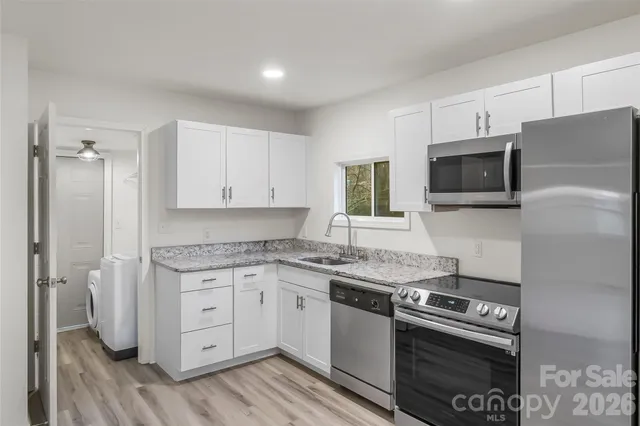a kitchen with stainless steel appliances granite countertop a stove a sink and a microwave
