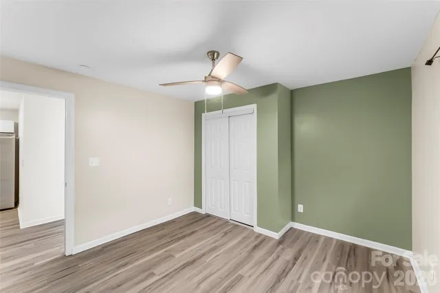 a view of room with wooden floor fan and window