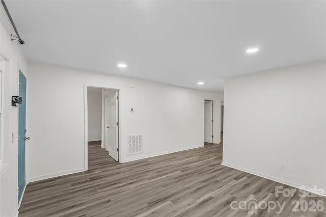 a view of an empty room with wooden floor