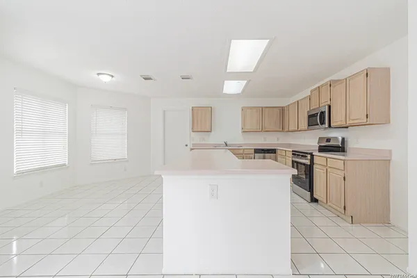 a kitchen with a sink a stove top oven and white cabinets