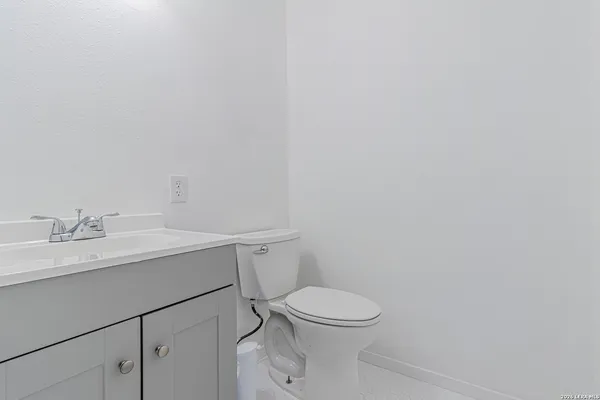 a bathroom with a toilet a sink and mirror