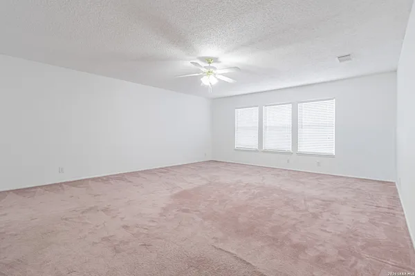 an empty room with a window and a ceiling fan