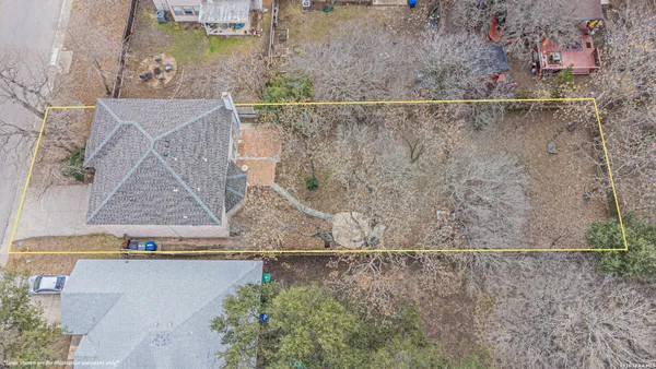 an aerial view of a house with a yard and large trees