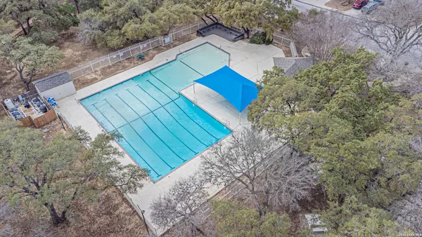 an aerial view of a house with a yard and a large tree