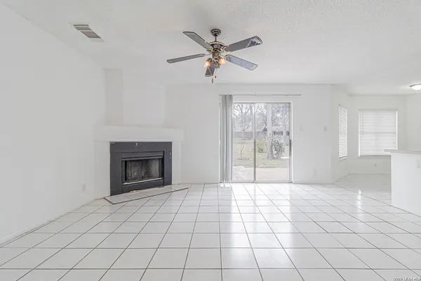 a view of an empty room with a fireplace and a window