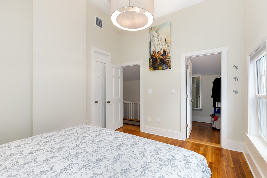 55 6th Street, Unit 55 Cambridge, MA 02141 - Photo 16 of 21 a bedroom with a bed and a chandelier