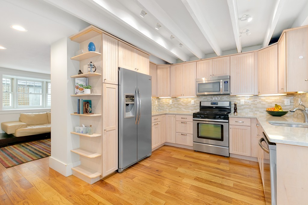 55 6th Street, Unit 55 Cambridge, MA 02141 - Photo 7 of 21 a kitchen with granite countertop a refrigerator and a stove top oven