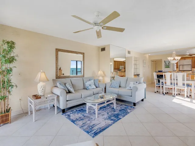 a living room with furniture a table and a large window