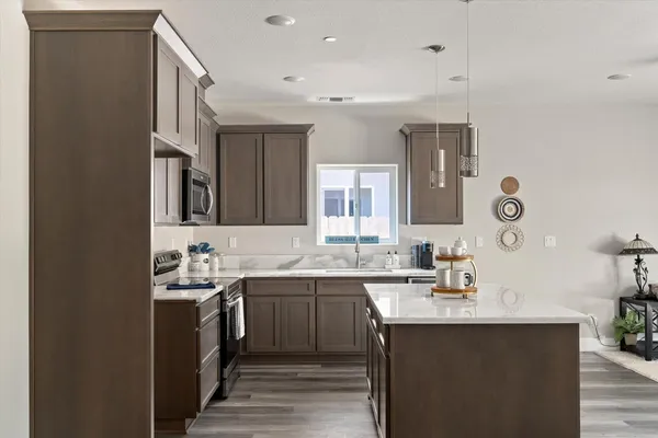 a kitchen with sink a mirror and cabinets