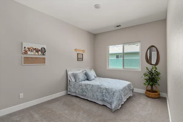 a bedroom with a bed and a potted plant