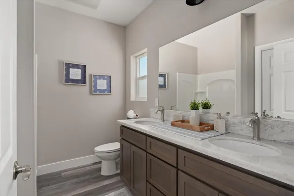 a bathroom with a granite countertop sink a toilet and a mirror