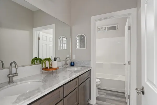 a bathroom with a granite countertop sink a toilet and a tub