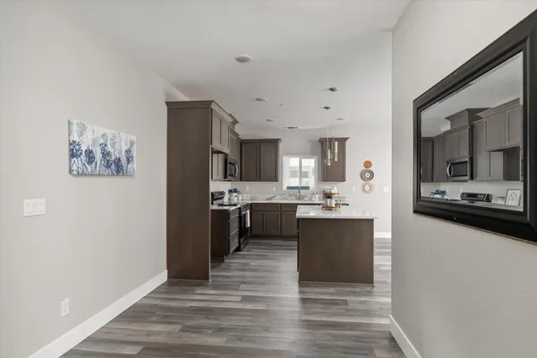 a view living room with stainless steel appliances kitchen island a sink wooden floor and view living room