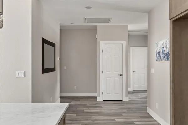 a view of a hallway with wooden floor and entryway