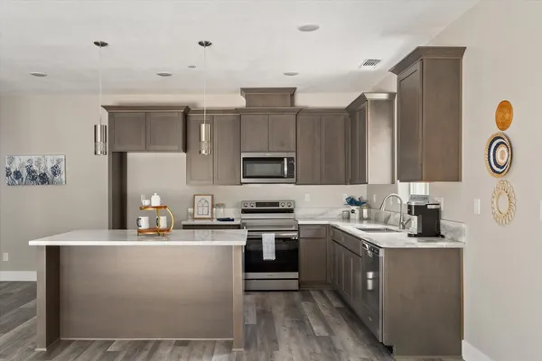 a kitchen with a sink a stove a refrigerator and cabinets