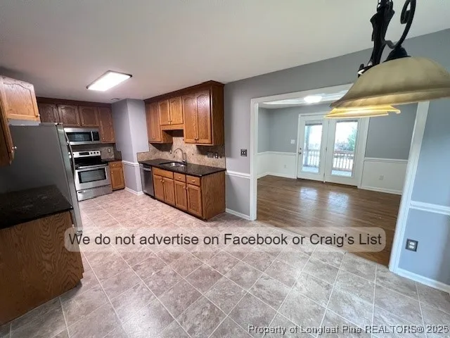 a kitchen with stainless steel appliances granite countertop a stove a sink and a refrigerator