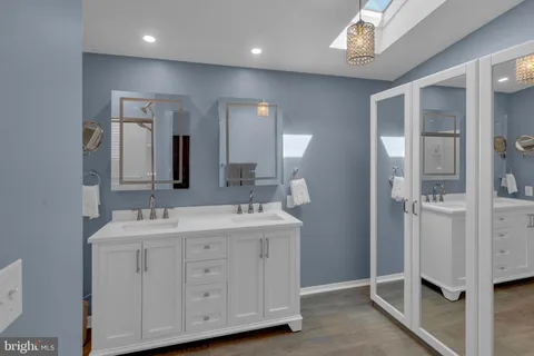 a spacious bathroom with a double vanity sink and mirror