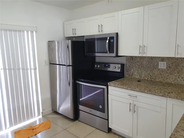 a kitchen with a refrigerator sink and cabinets