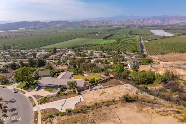 an aerial view of a city with lots of residential buildings and mountain view in back