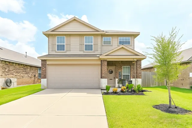 a front view of a house with a yard and garage
