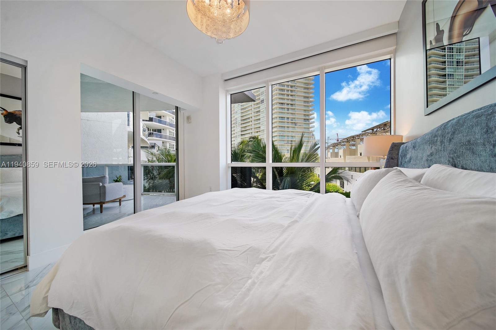 400 Alton Road, Unit 409 Miami Beach, FL 33139 - Photo 15 of 25 a bedroom with a large bed and a large window