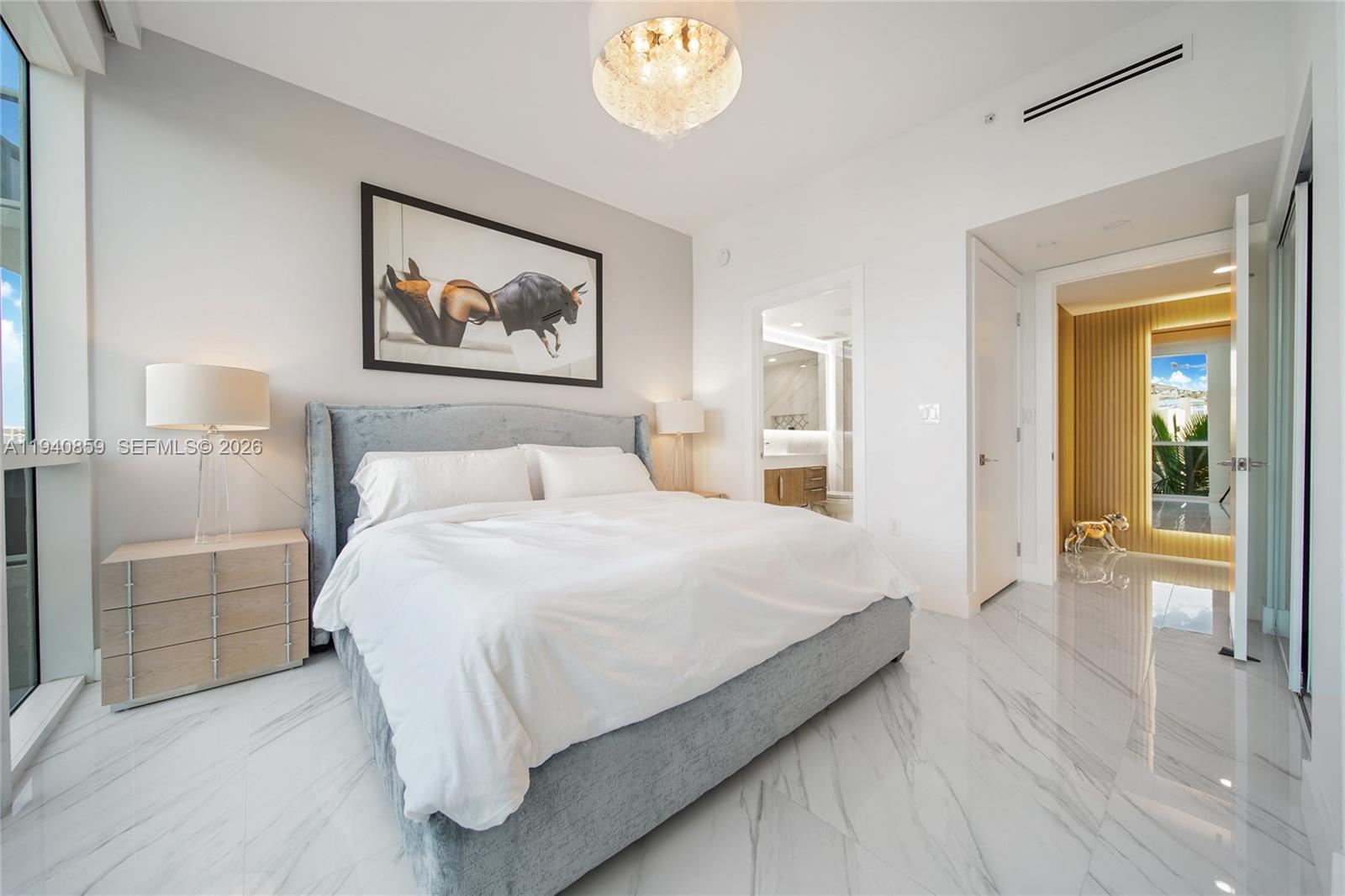 400 Alton Road, Unit 409 Miami Beach, FL 33139 - Photo 17 of 25 a bedroom with a bed and a chandelier