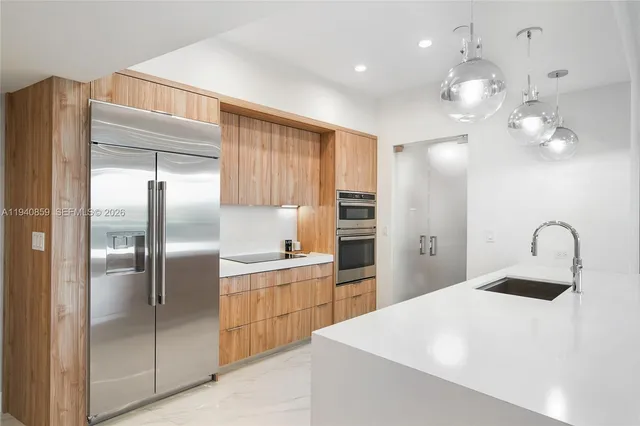 a kitchen with kitchen island a counter top space cabinets and stainless steel appliances