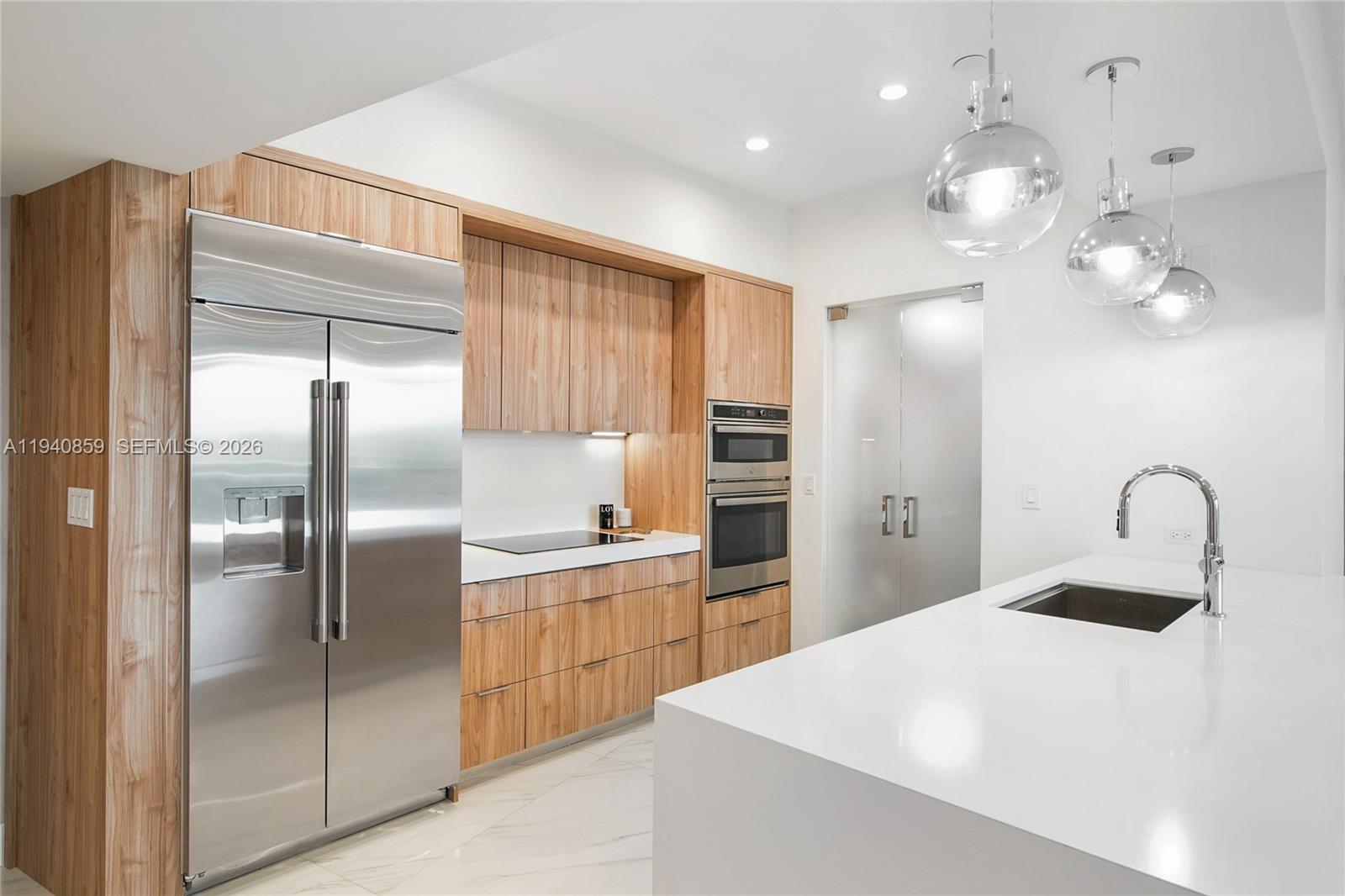 400 Alton Road, Unit 409 Miami Beach, FL 33139 - Photo 2 of 25 a kitchen with kitchen island a counter top space cabinets and stainless steel appliances