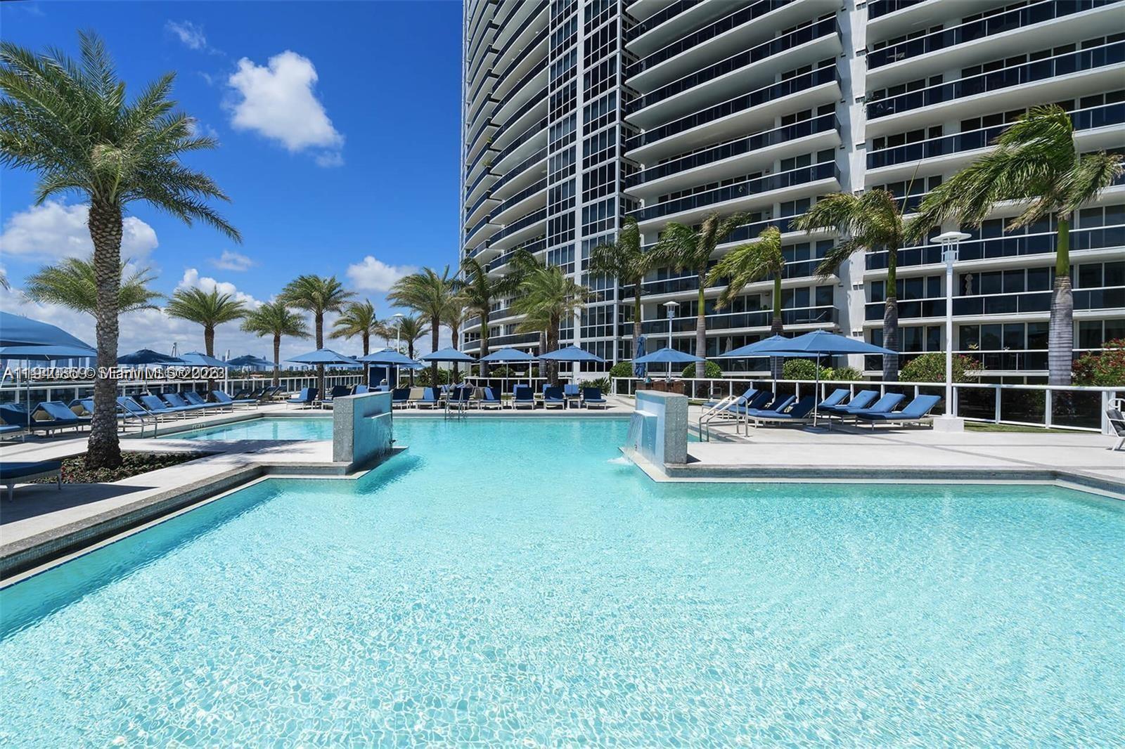 400 Alton Road, Unit 409 Miami Beach, FL 33139 - Photo 22 of 25 a view of a swimming pool with a table and chairs