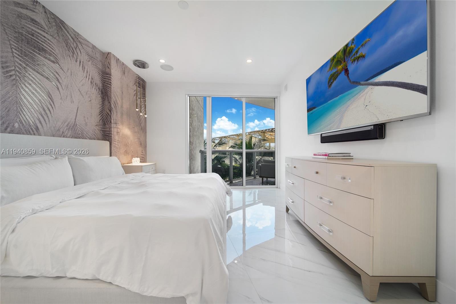 400 Alton Road, Unit 409 Miami Beach, FL 33139 - Photo 9 of 25 a bedroom with a bed and a flat tv screen on dresser