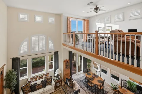 a view of a patio with table and chairs potted plants and floor to ceiling window