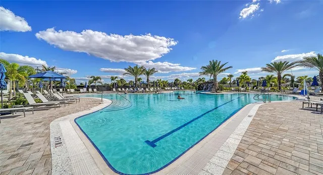 a view of a balcony with chairs and umbrella