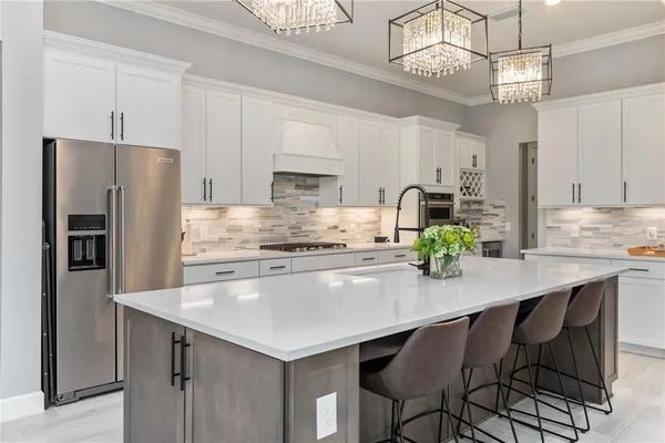 a kitchen with granite countertop a table chairs stainless steel appliances and cabinets