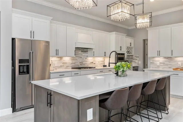 a kitchen with granite countertop a table chairs stainless steel appliances and cabinets