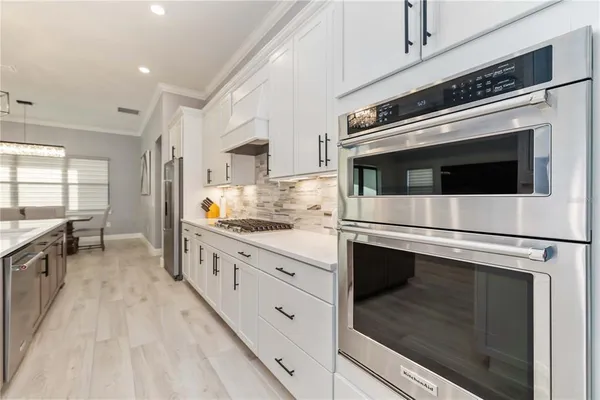 a kitchen with stainless steel appliances white cabinets and white appliances