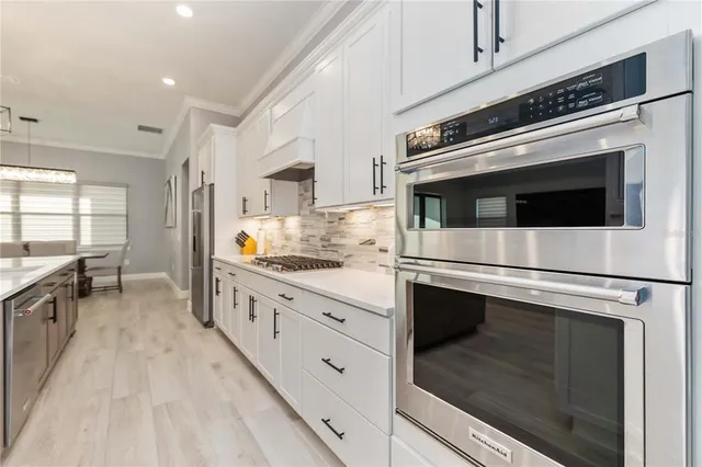a kitchen with stainless steel appliances white cabinets and white appliances