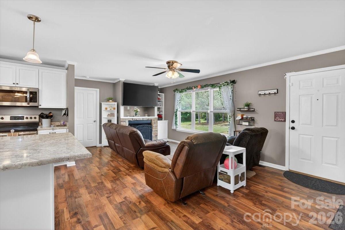 567 Godbey Road Mocksville, NC 27028 - Photo 2 of 38 a living room with furniture a fireplace and a dining table with wooden floor