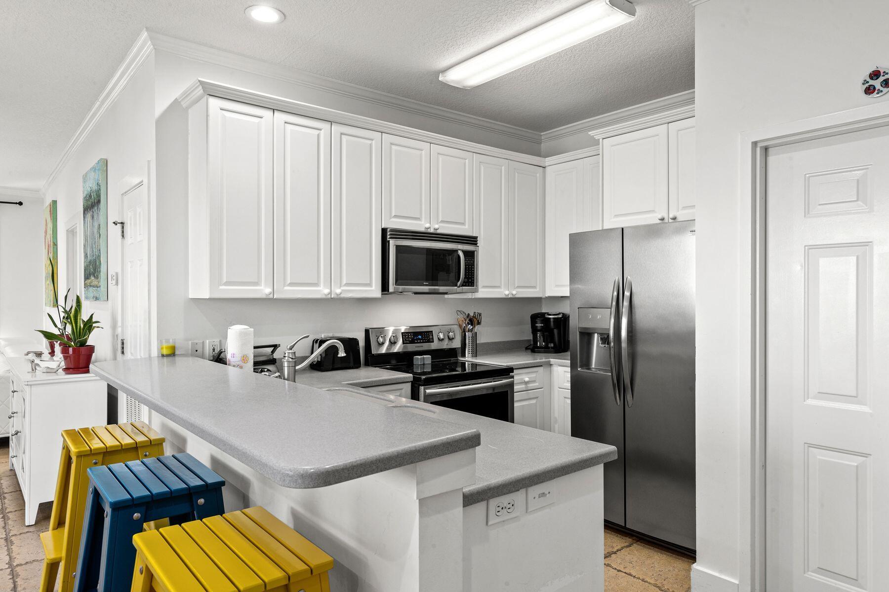 120 Quincy Circle Santa Rosa Beach, FL 32459 - Photo 19 of 26 a kitchen with a sink a refrigerator and cabinets