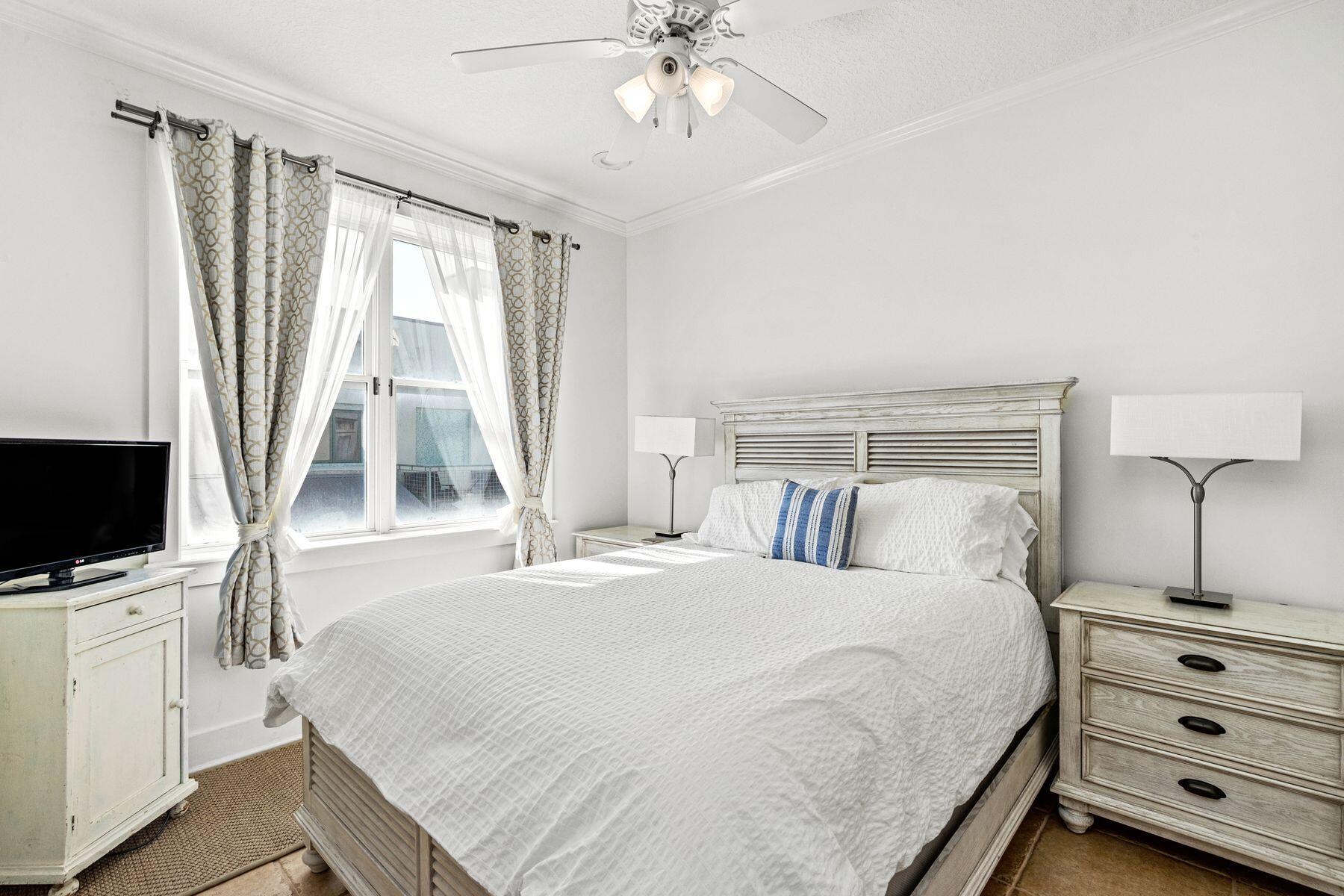 120 Quincy Circle Santa Rosa Beach, FL 32459 - Photo 21 of 26 a bedroom with a bed and a flat tv screen on a dresser