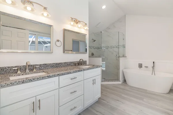 a bathroom with a granite countertop sink mirror and bathtub