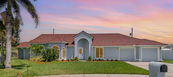 a front view of a house with a yard and trees