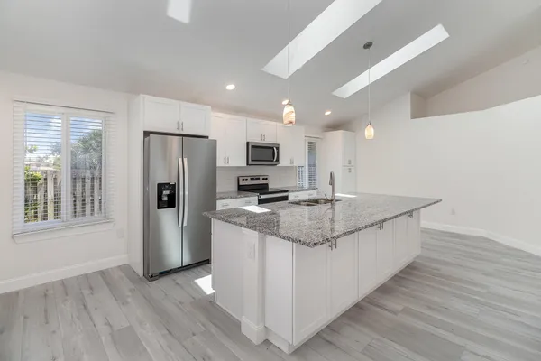 a kitchen with stainless steel appliances granite countertop a refrigerator and a stove