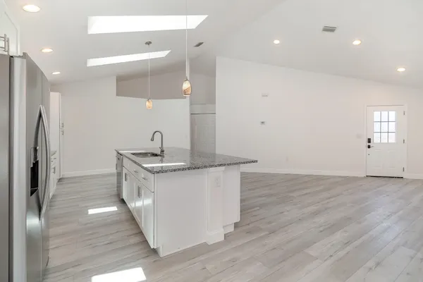 a kitchen with stainless steel appliances granite countertop a sink stove and refrigerator