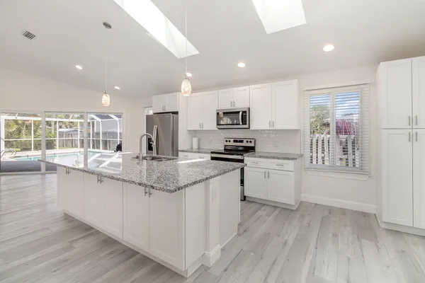 a kitchen with stainless steel appliances granite countertop a sink and cabinets