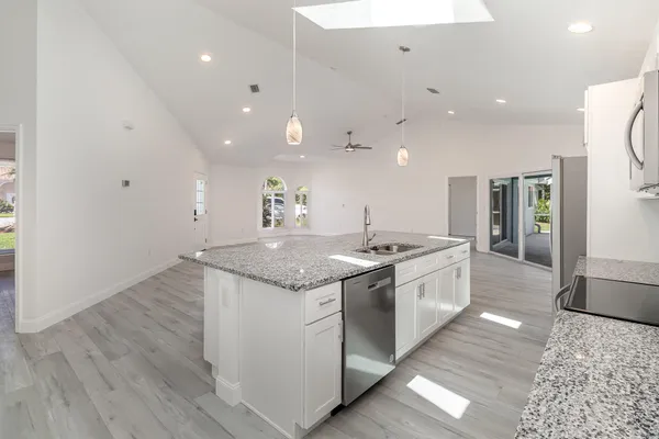 a large kitchen with kitchen island a sink stainless steel appliances and cabinets