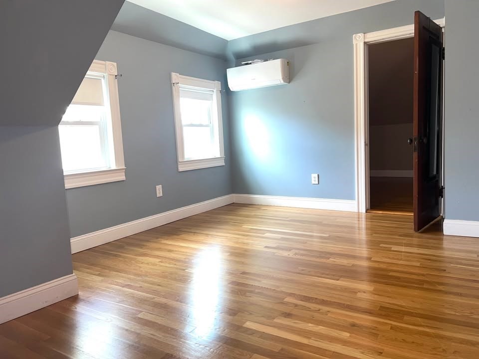 29 Richie Road, Unit 2 Quincy, MA 02169 - Photo 19 of 30 an empty room with wooden floor and windows