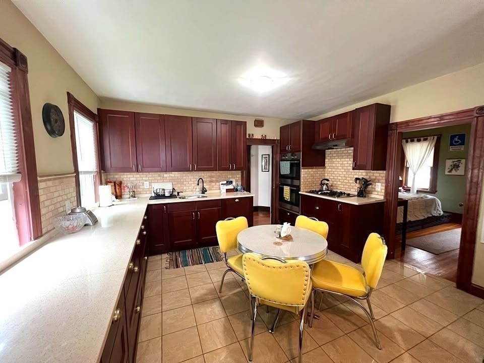 29 Richie Road, Unit 2 Quincy, MA 02169 - Photo 5 of 30 a kitchen with granite countertop stainless steel appliances a stove a sink a microwave a dining table and chairs