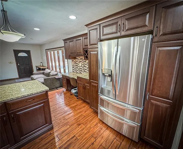 a kitchen with stainless steel appliances granite countertop a refrigerator and a stove