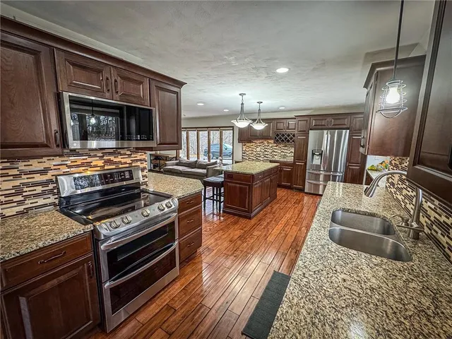 a kitchen with stainless steel appliances granite countertop a stove and a sink